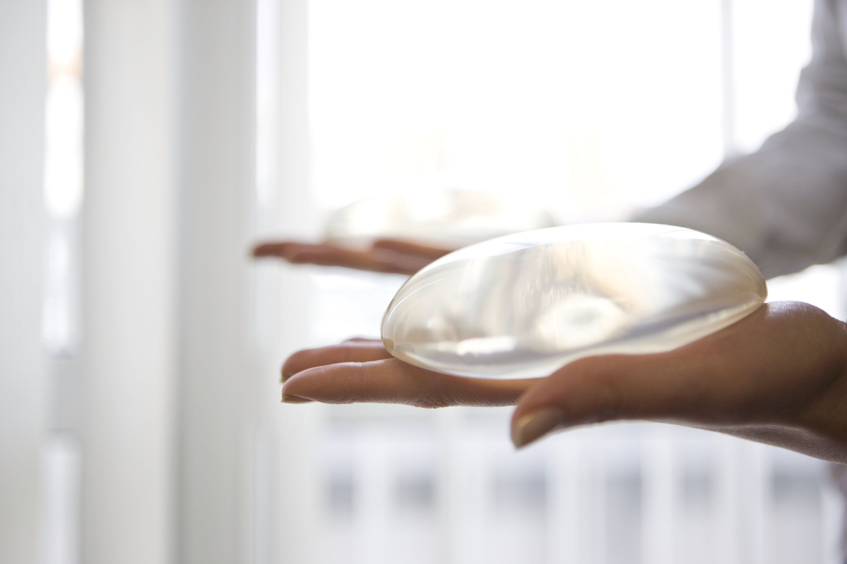 A person holding a saline breast implant